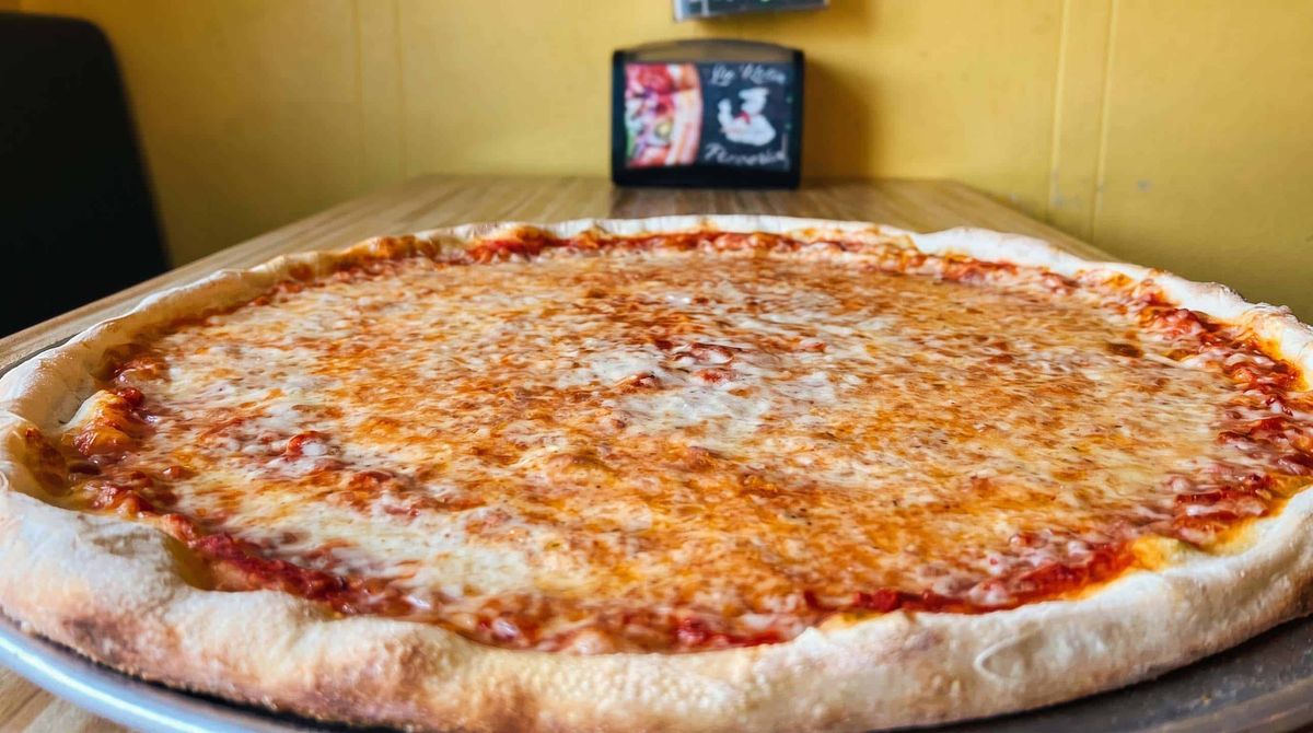 A large plain cheese pie on the counter at La Rosa Pizza
